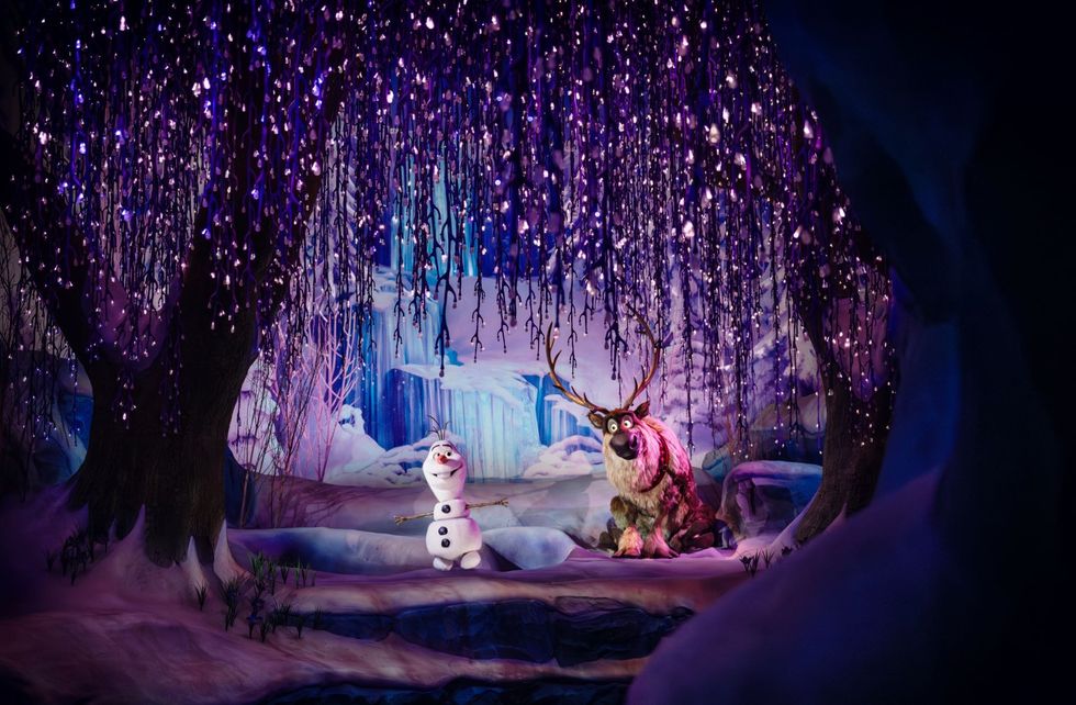 Olaf and Sven under sparkling purple lights in a snowy, enchanted forest scene at Disney Adventure World