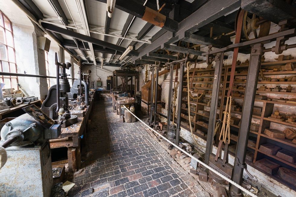 Old industrial workshop with vintage machinery and brick floor.