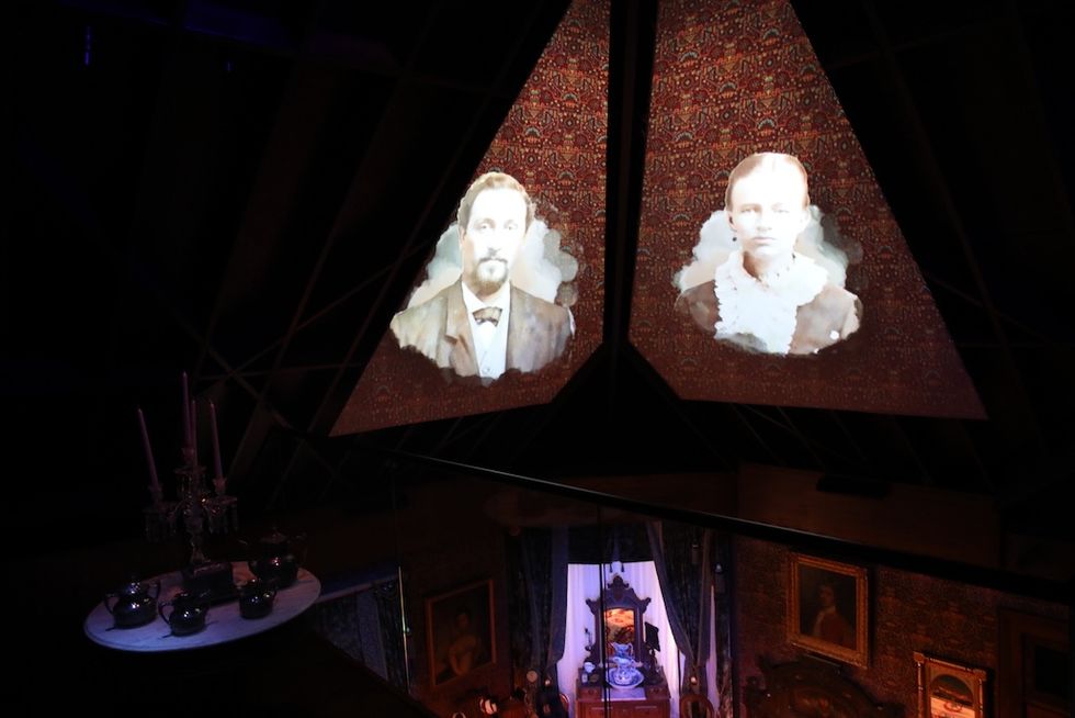 Old portraits projected on a triangular surface in a dimly lit room at Schifferdecker and Zelleken homes