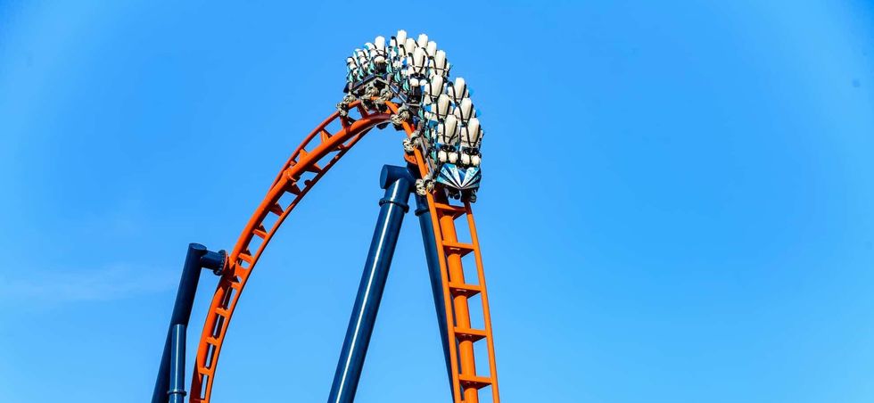 Orange roller coaster loop against a clear blue sky at SeaWorld Orlando