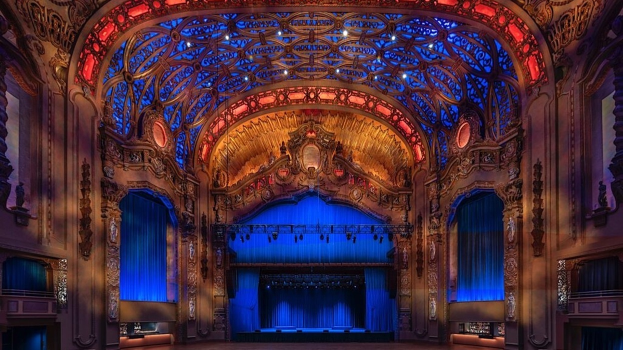 Ornate Brooklyn Paramount Theater interior with red and blue ceiling lights and intricate architectural details.