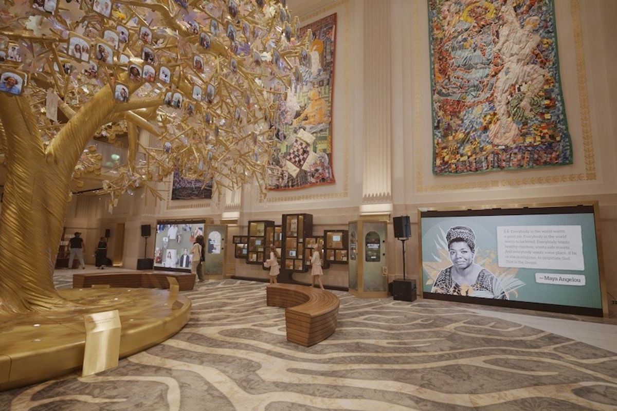 Ornate hall with golden tree and colorful murals; Maya Angelou quote on screen. the Milken Center for Advancing the American Dream