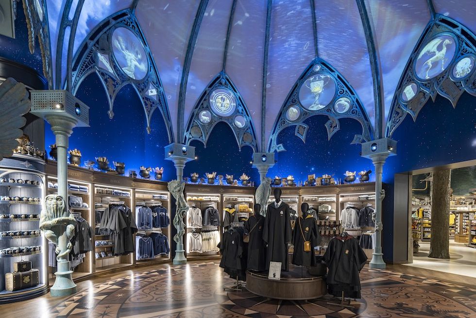 Ornate store with wizard-themed decor and clothing under a starry, vaulted ceiling.