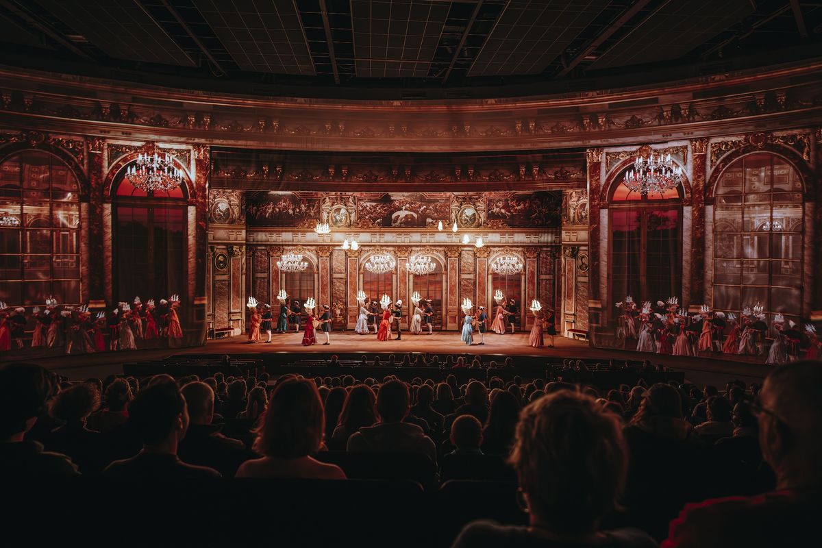 Ornate theater scene from Le Dernier Panache at Puy du Fou with actors in period costumes, viewed by an audience.