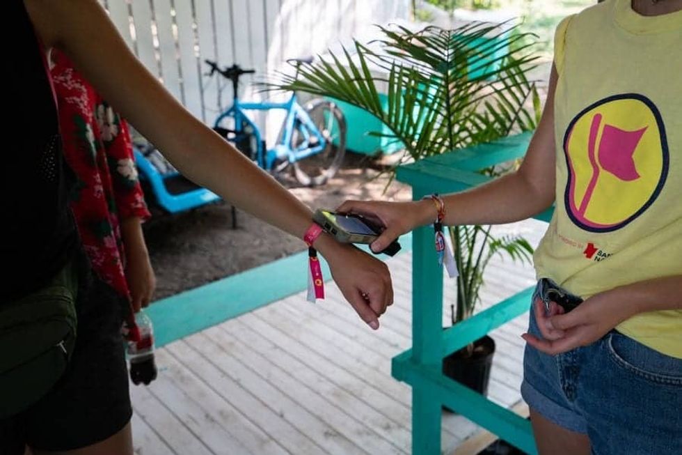 Osheaga Music and Arts Festival guest getting her Connect&GO's RFID wristband scanned by staff