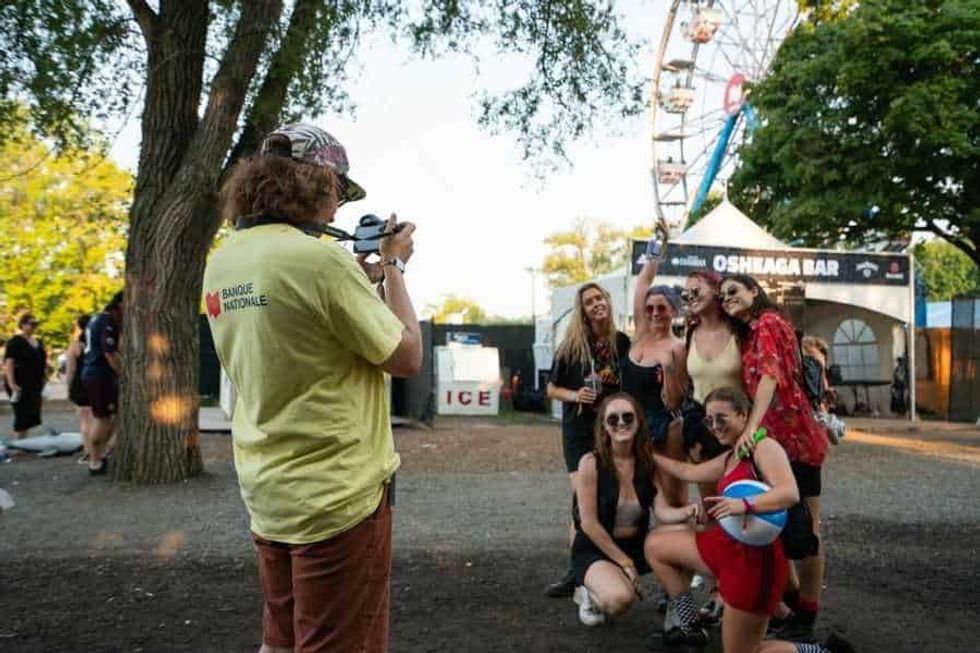 Osheaga Music and Arts Festival staff taking picture for a group of guests outside the Osheaga Bar