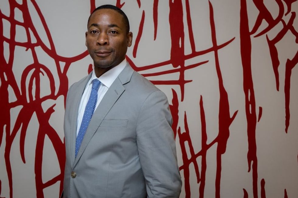 PAMM Director Franklin Sirmans poses with Arturo Herrera’s site-specific work, When Alone Again III, 2001.
