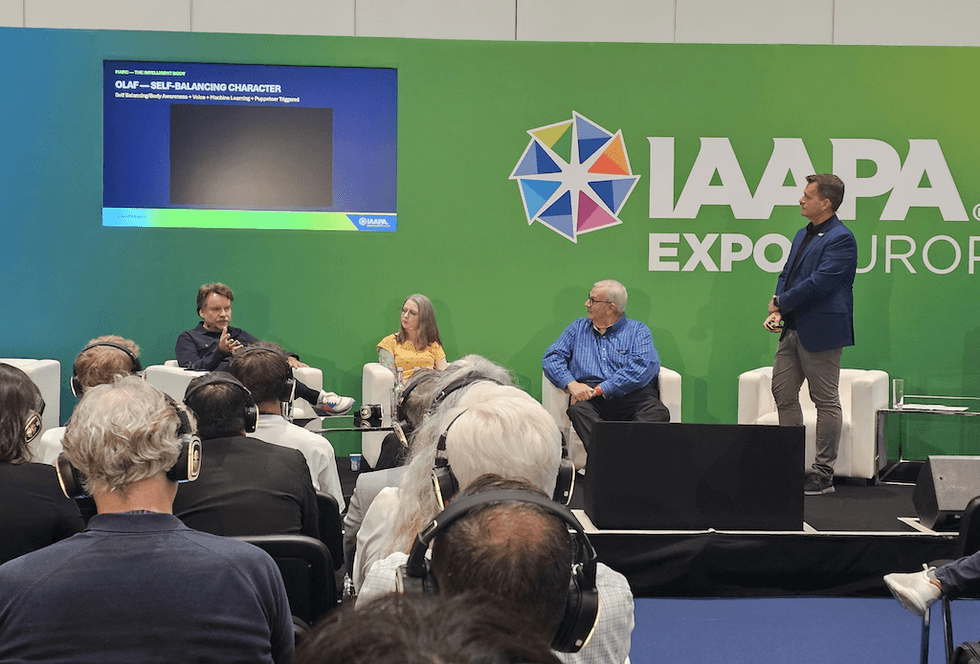 Panel discussion at IAAPA Expo Europe with four people on stage.