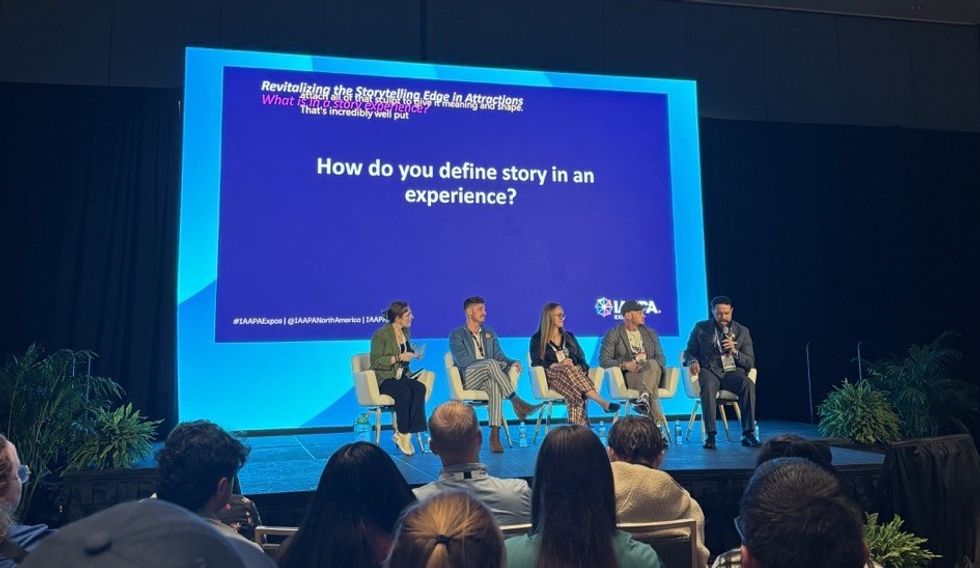 Panel discussion on storytelling in attractions, featuring five speakers on a stage.