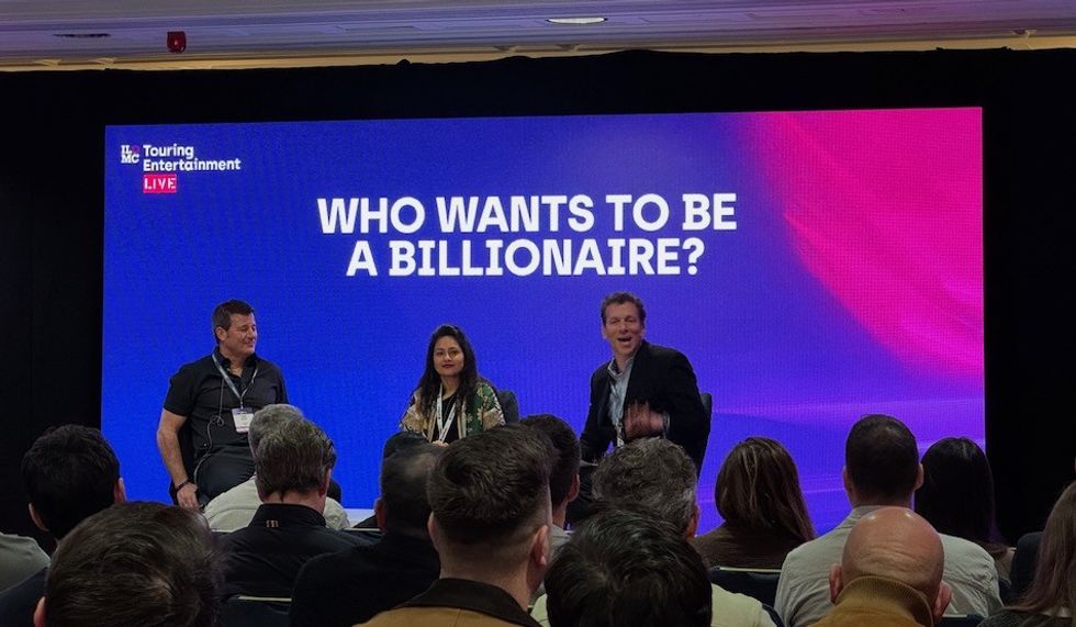 Panel discussion titled "Who Wants to Be a Billionaire?" with a live audience.