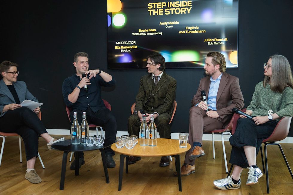 Panel discussion with five people seated, exchanging ideas on stage.