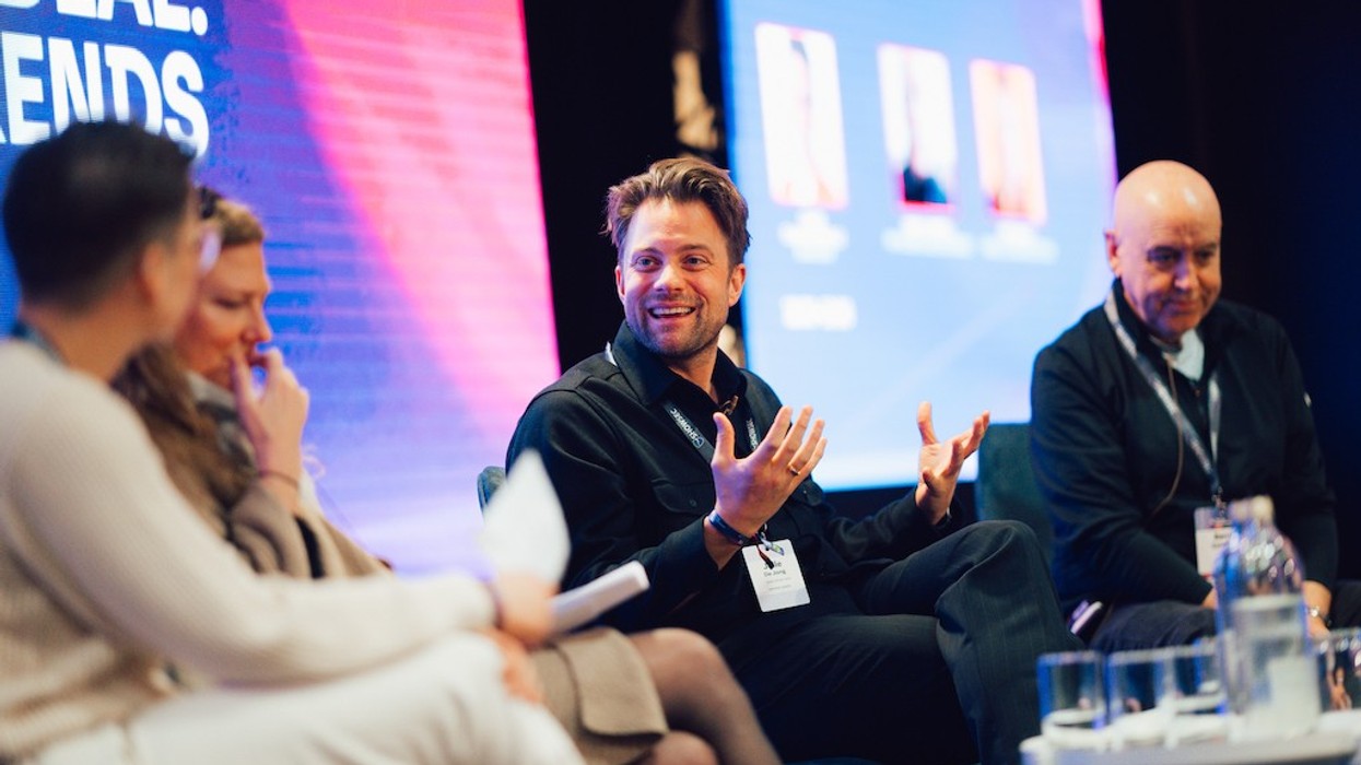 Panel discussion with smiling man speaking, others listening attentively.