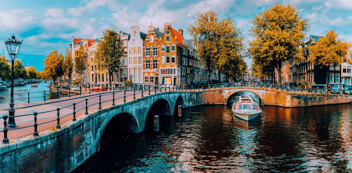 Panorama of Amsterdam. Famous canals und bridges at warm afternoon light. Netherlands.