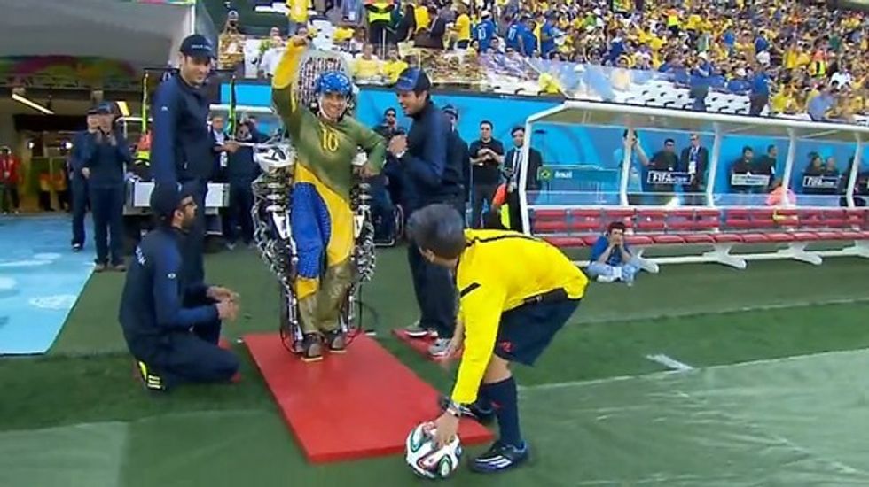 paraplegic with a mind controlled exo-skeleton taking the first kick of the world cup