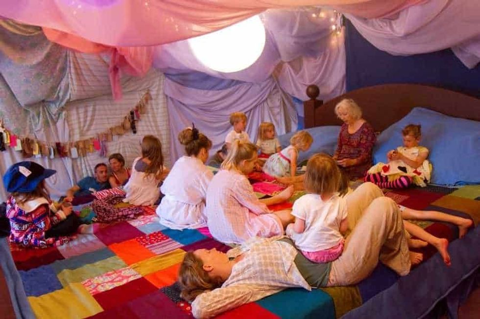 Parents and children on the giant story bed at The Story Museum