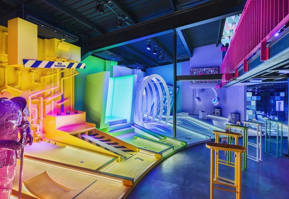 Partial view of BOXPARK Wembley Pop Golf mini course lit with rainbow lights
