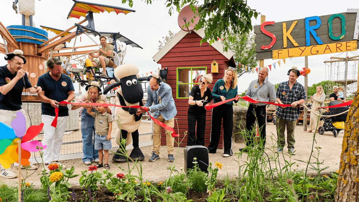 People and a Shaun the Sheep character cut a red ribbon at an outdoor amusement park opening, Scrap Flyer at Skanes Djurpark