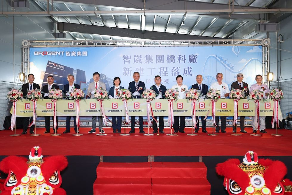 People at a ribbon-cutting ceremony with a "Brogent" banner and lion dancers.