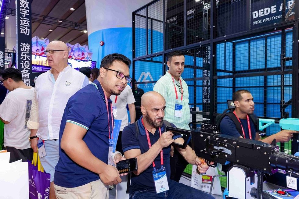 People at an event trying a shooting game simulator.