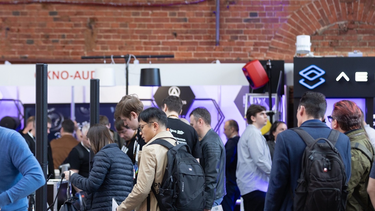 People attending a tech expo, interacting at various booths.