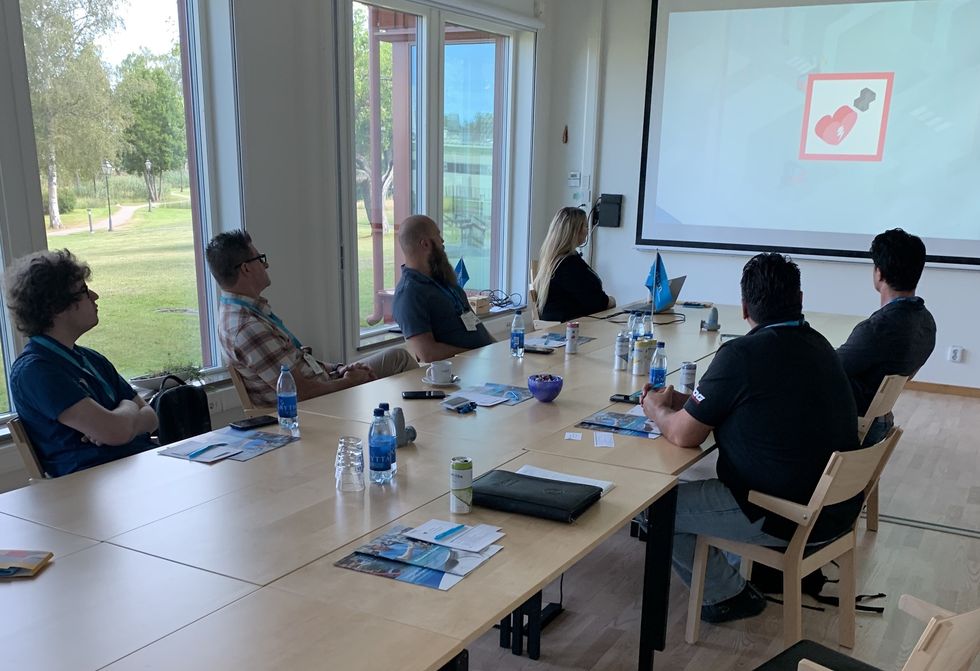 People attentively watching a presentation in a well-lit conference room.