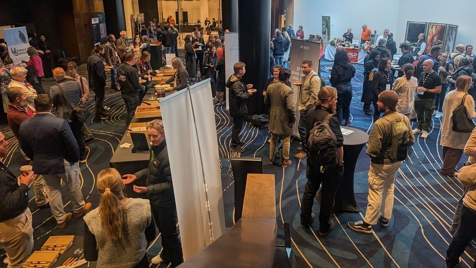 People engaging at the 2026 ZAA conference with various booths and displays.