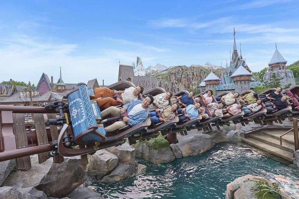 People enjoy a thrilling roller coaster ride in a fantasy-themed amusement park.