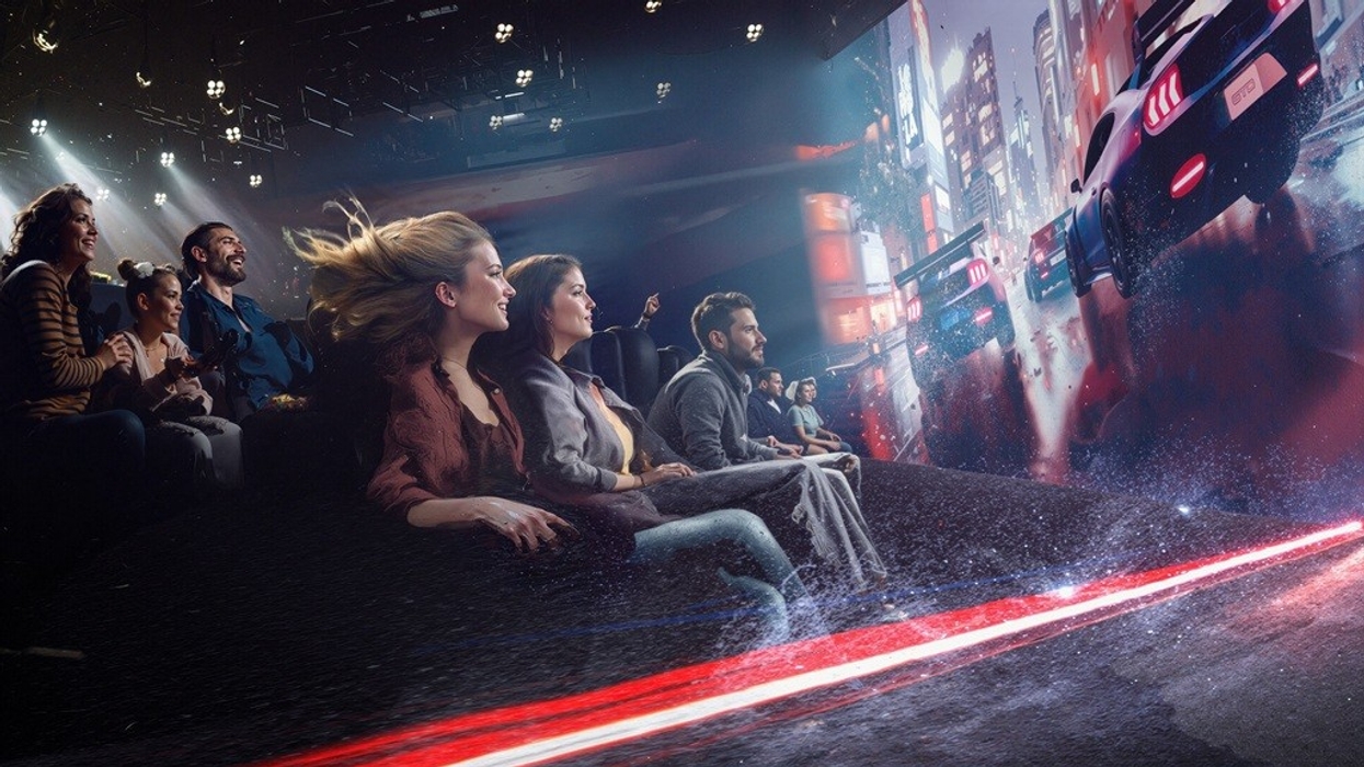 People enjoying a car racing simulator with a cityscape screen.
