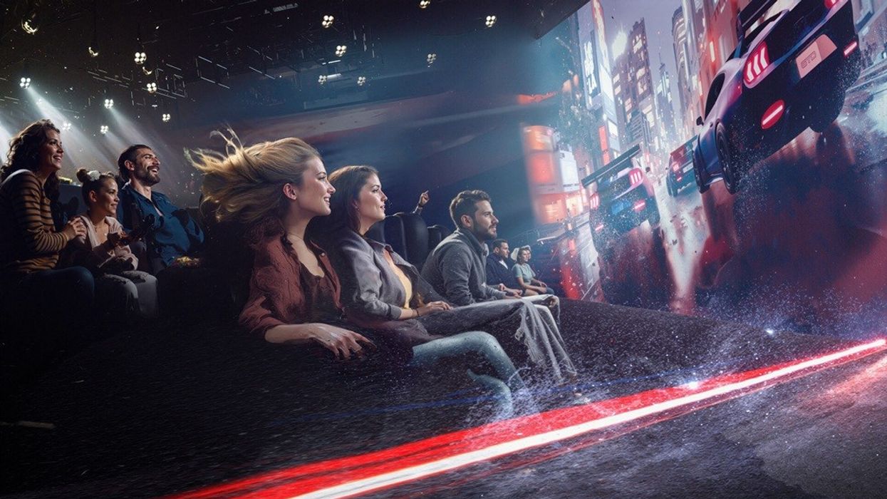 People enjoying a car racing simulator with a cityscape screen.