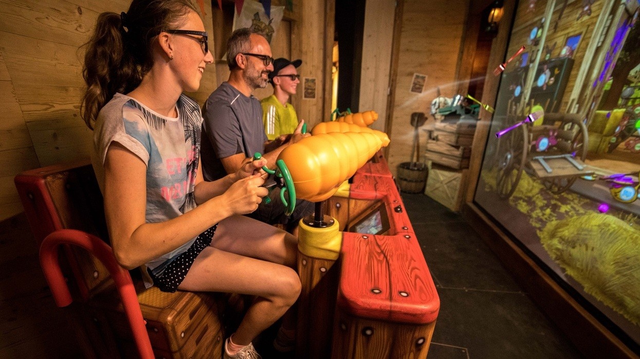 People enjoying a carrot-themed arcade shooting game indoors.