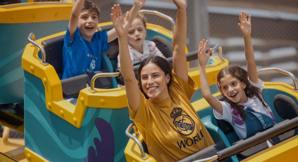 People enjoying a roller coaster ride, with hands raised and smiling.