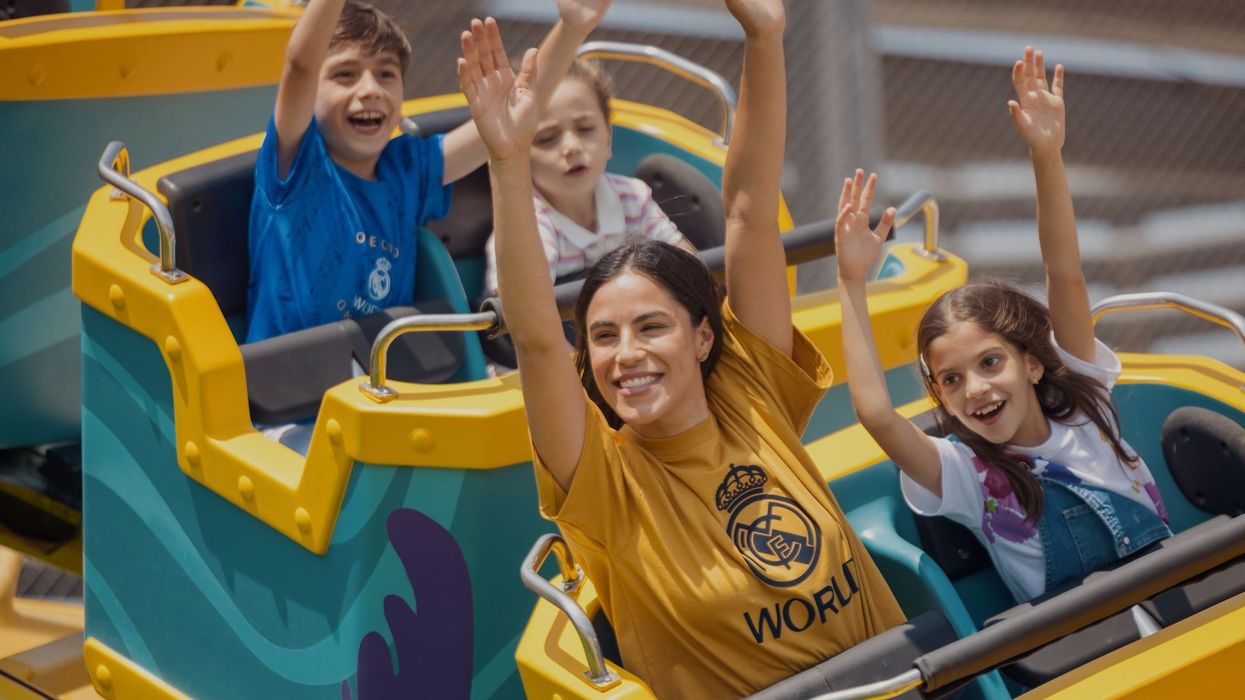 People enjoying a roller coaster ride, with hands raised and smiling.