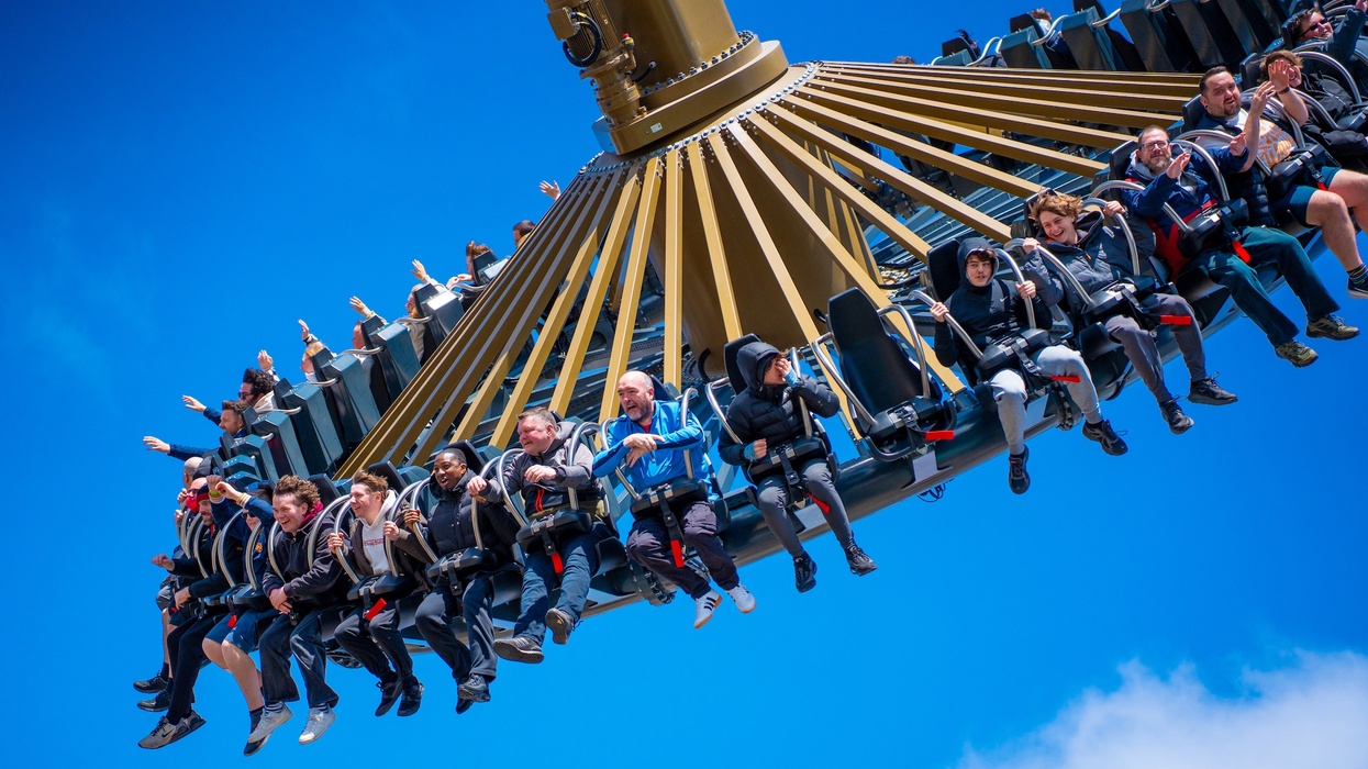 People enjoying a swing ride against a blue sky.