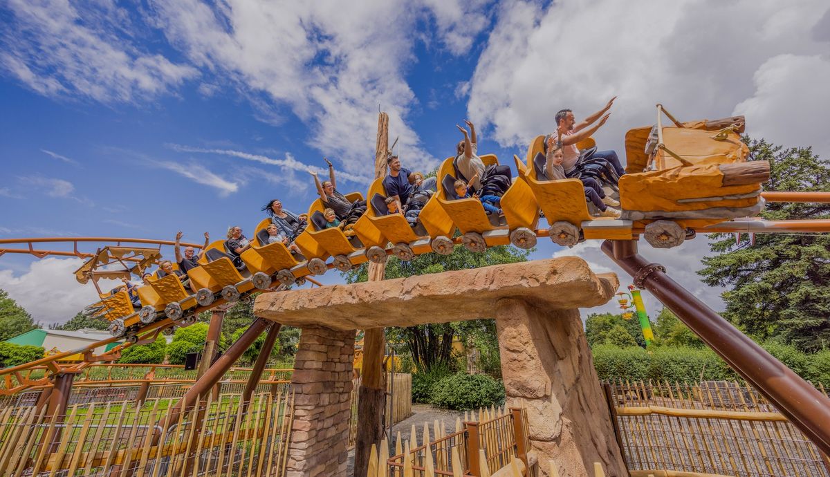 People enjoying a thrilling roller coaster ride, Braus and Saus, under a clear blue sky at Potts Park