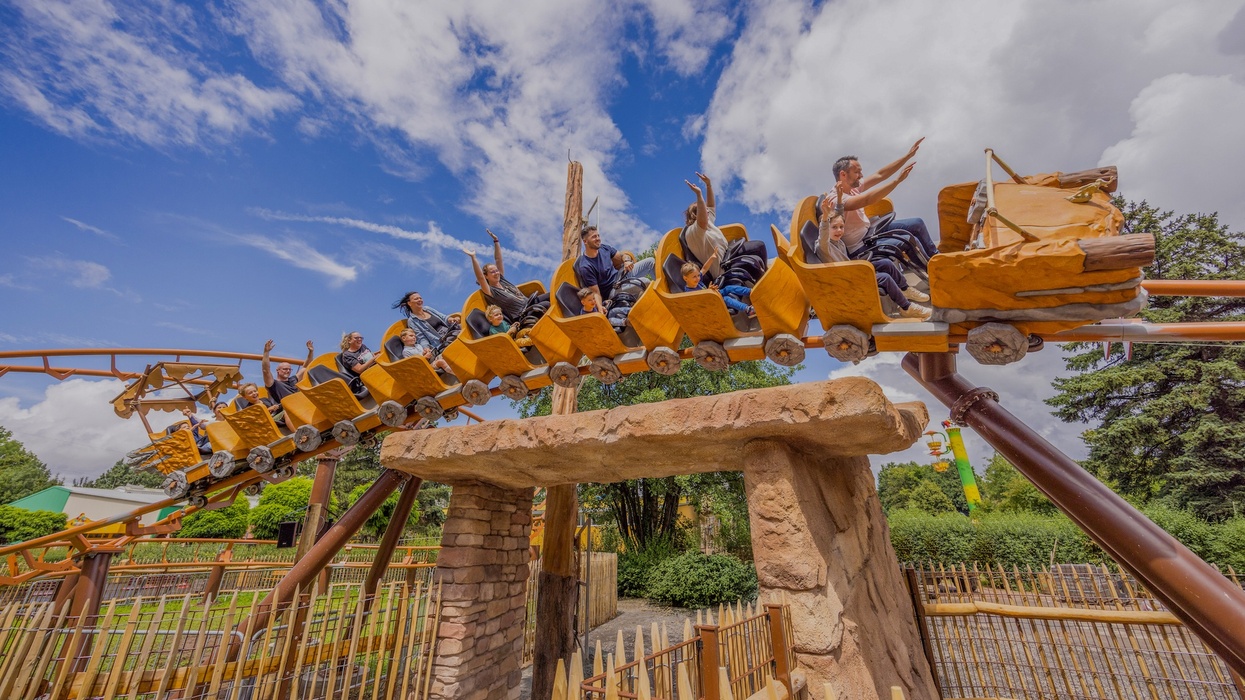 People enjoying a thrilling roller coaster ride, Braus and Saus, under a clear blue sky at Potts Park