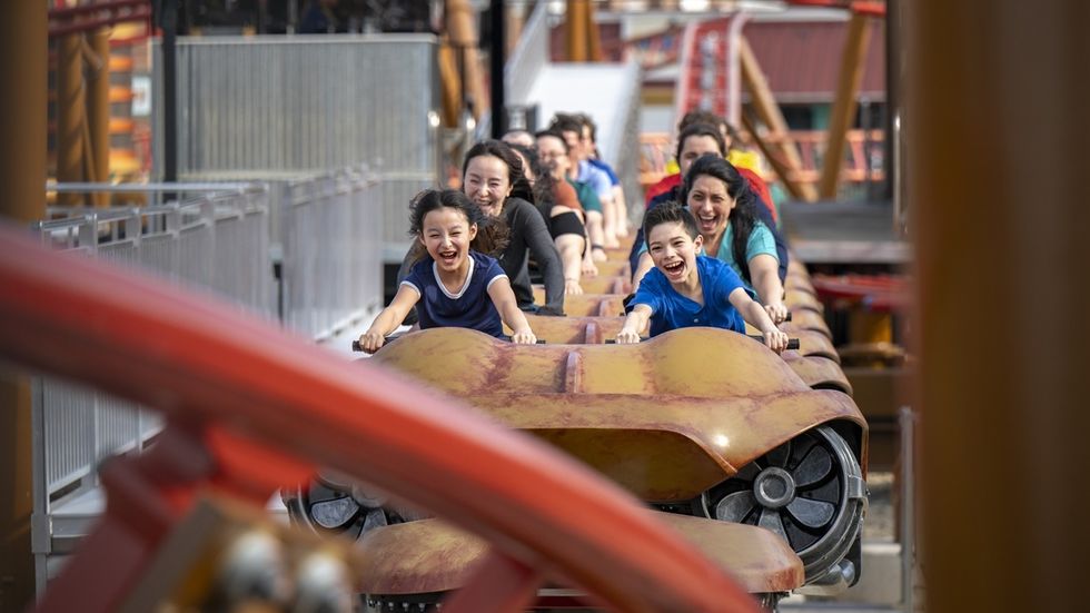 People enjoying a thrilling roller coaster ride, smiling and laughing.