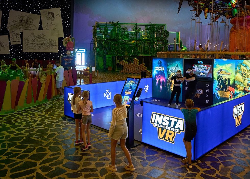 People enjoying VR games and activities in a colorful indoor entertainment center.
