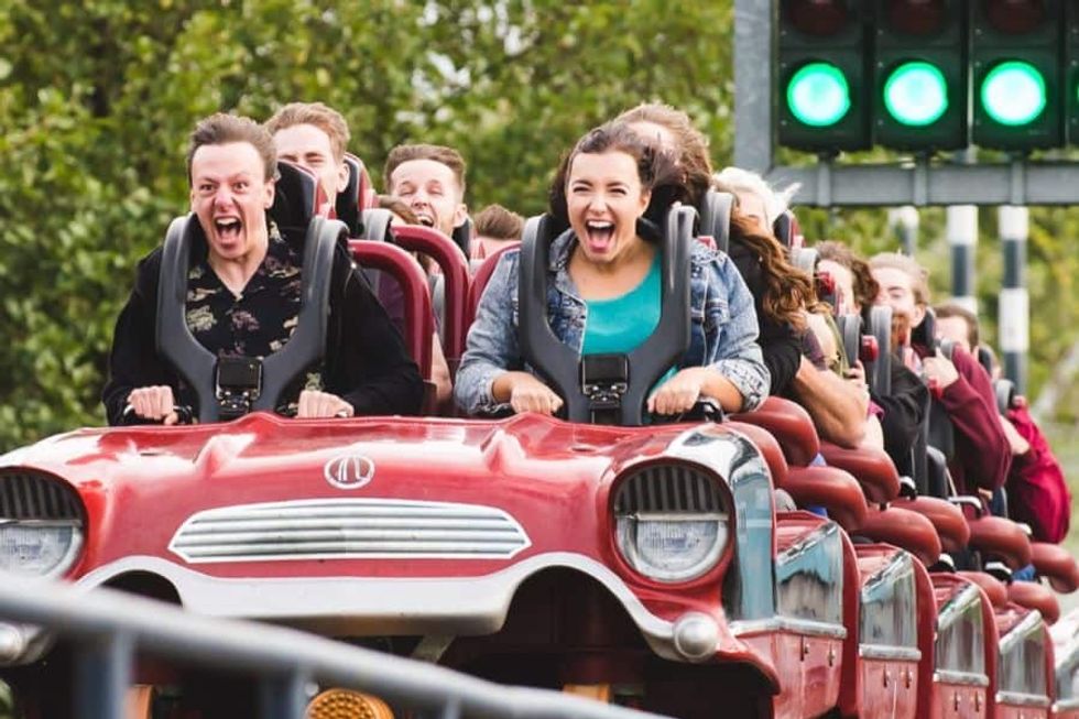 People excitedly riding Stealth at Thorpe Park - a roller coaster styled like a vintage car.
