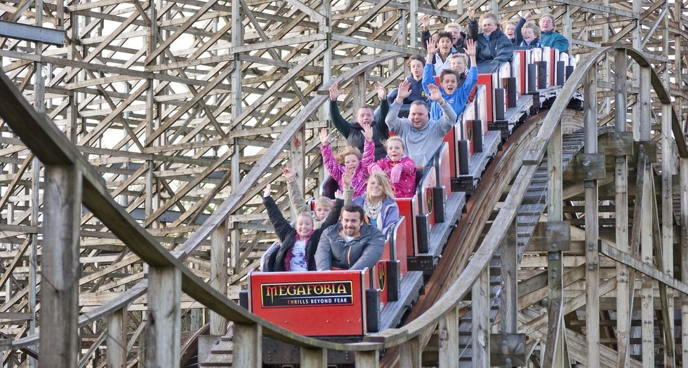 People excitedly riding the Megafobia wooden roller coaster.