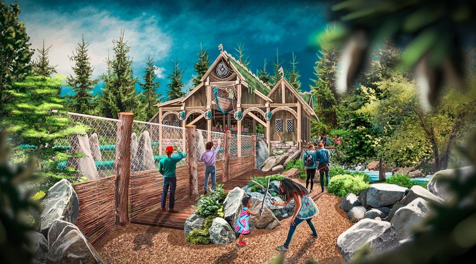 People exploring a rustic cabin at Djurs Sommerland, in a forest setting with rocks and trees around.
