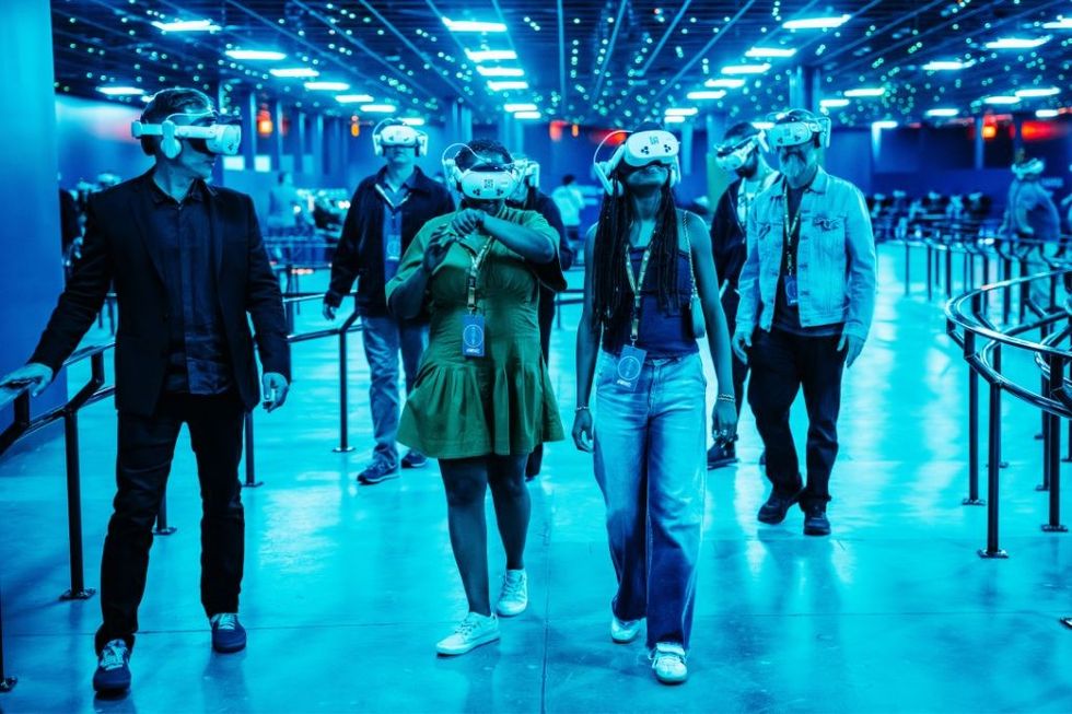 People exploring a virtual reality space wearing VR headsets, blue lighting everywhere.