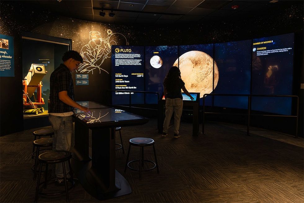 People exploring Ideum's Journey to Pluto exhibit at Las Cruces Museum of Nature and Science.