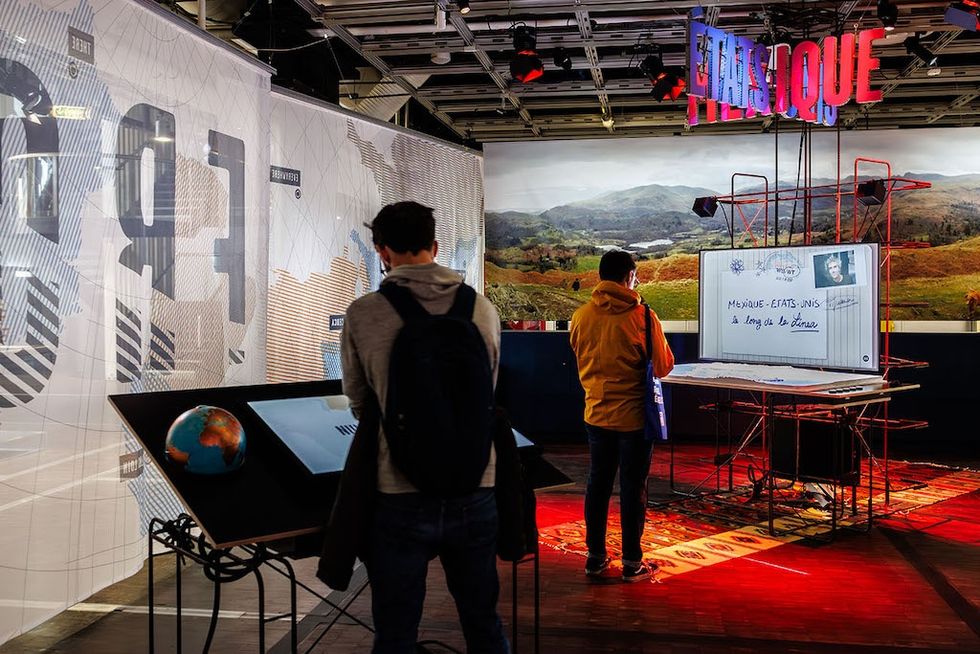 People exploring interactive exhibits in a modern museum setting.