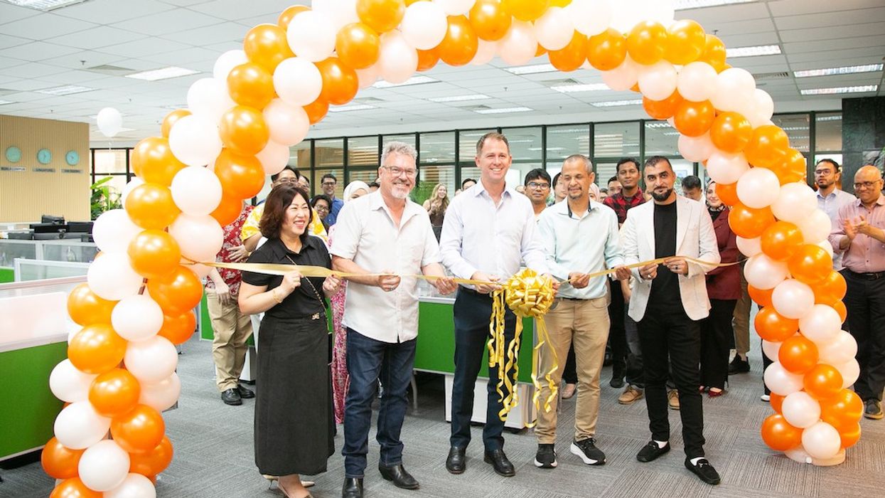 People gathered for a ribbon-cutting ceremony under a balloon arch in Pico Play's new design space in KL