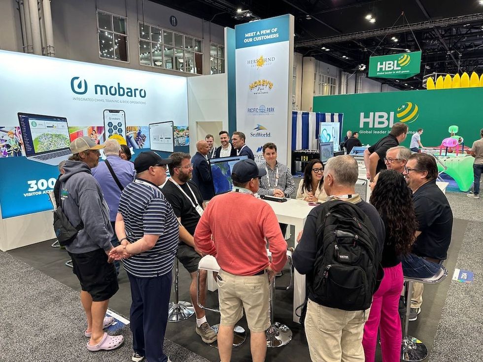 People gathering at a Mobaro booth at a trade show, discussing and viewing displays.