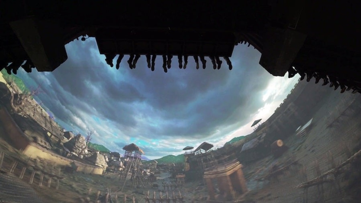 People hanging upside down on a thrill ride with a gloomy sky in the background, flying theatre experience at Hengdian World Studios