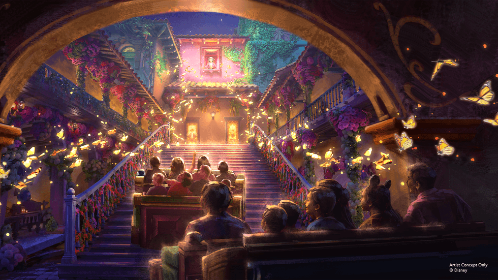 People in a courtyard, surrounded by glowing butterflies and vibrant flowers on Disney's Encanto ride