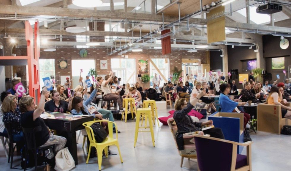 People in a creative workspace raising cards during a group activity.
