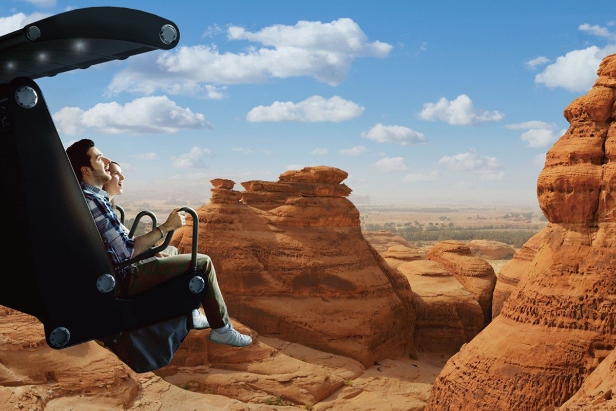 People in a simulated ride soaring over a scenic desert landscape.