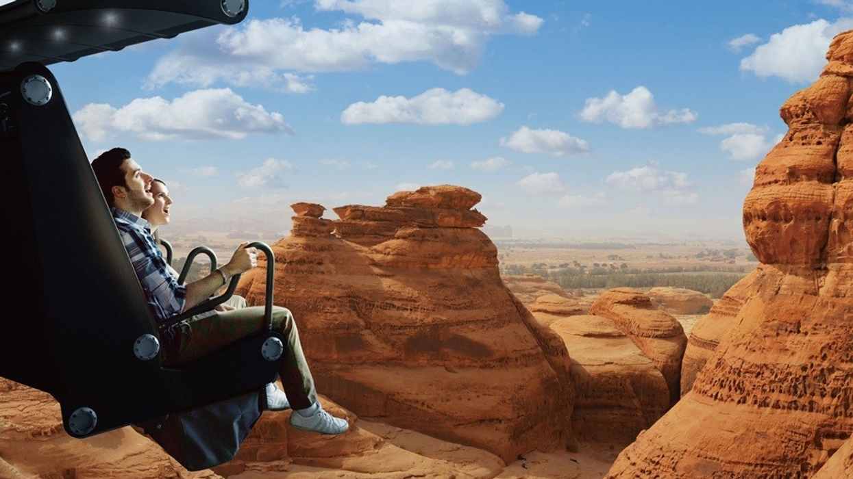 People in a simulated ride soaring over a scenic desert landscape.